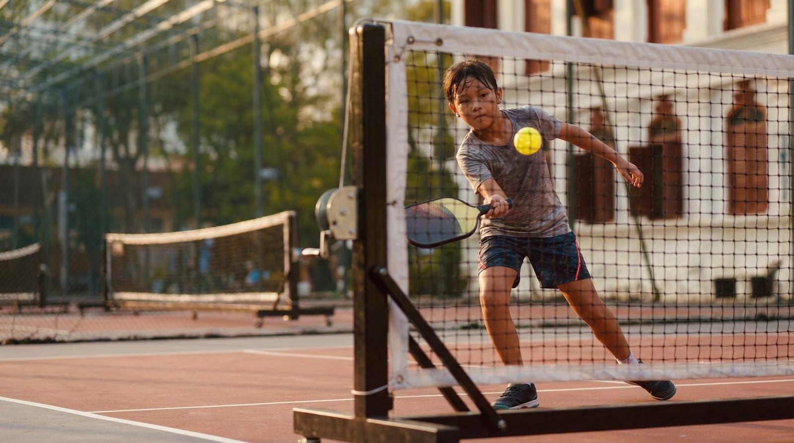 Child focused on a pickleball stroke during training